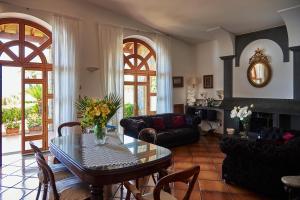 a living room with a table and chairs at Villa Favara in Scala +20 photos