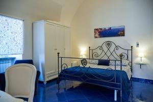 a blue bedroom with a bed and a chair at Villa Favara in Scala