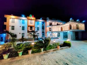 a group of buildings at night with palm trees at Hotel Sanwariya in Kot Pūtli