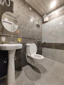 a bathroom with a toilet and a sink and a mirror at Hotel Sanwariya in Kot Pūtli