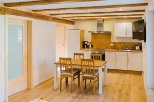 a kitchen with a table and chairs in a room at Hellbachhof in Equarhofen