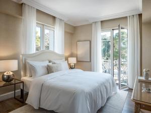 a bedroom with a large white bed and windows at Grecotel Larissa Imperial in Larisa +64 photos