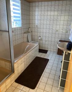 a bathroom with a tub and a toilet and a sink at Haus Schwarzwald Marie in Mahlberg +27 photos