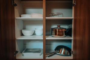 a cupboard filled with plates and bowls and a pot at Casa De Una Tagaytay in Galicias +16 photos