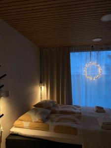 a bedroom with a bed and a window with a wreath at HALLA-mökki in Tyrnävä