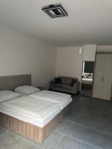a bedroom with a bed and a couch at Hotel Johannisberg Bad Homburg in Bad Homburg vor der Höhe