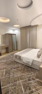 a bedroom with a bed and a stone floor at عز الاصالة للشقق المخدومة تصنيف اقتصادي in Taif