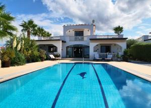 a villa with a swimming pool in front of a house at Villa Olive View in Kyrenia