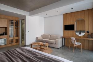 ein Schlafzimmer mit einem Bett, einer Couch und einem Tisch in der Unterkunft The Oak Hotel in Keramotí