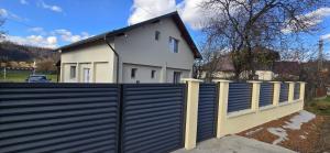 a fence in front of a white house at Casa Campionilor in Hodoşa