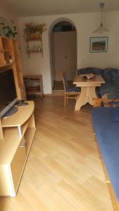 a living room with a wooden floor and a table at Casa Di Girolamo in Predazzo