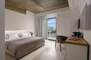 ein Schlafzimmer mit Bett, Schreibtisch und Fenster in der Unterkunft The Oak Hotel in Keramotí + 136 Fotos