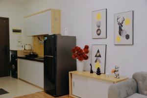 a kitchen with a black refrigerator and a table with flowers at TPHomes 12 - The Sun Avenue in Ho Chi Minh City