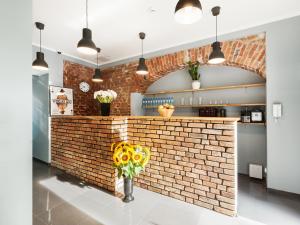 a kitchen with a brick wall and a vase of sunflowers at Cinema Hostel in Poznań