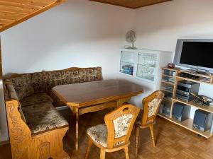 a living room with a table and a couch and a television at Dachgeschosswohnung im zweiten Obergeschoss in Bruck in der Oberpfalz