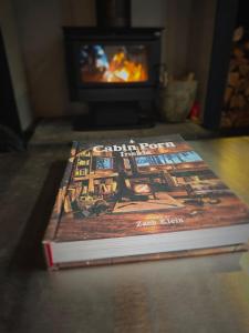 a book sitting on a table in front of a fireplace at Nordic Noir Cabin in Queenstown