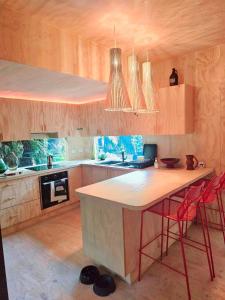 a kitchen with a table and two red chairs at Nordic Noir Cabin in Queenstown