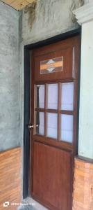 a wooden door with a window in a room at เวียงล้านนา รีสอร์ท in Ban Muang Pha