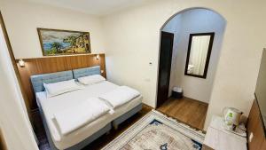 a bedroom with a white bed and a mirror at Samarkand Travel in Samarkand