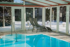 a patio with chairs and a swimming pool at Aparthotel Pfeffermühle in Ramsau am Dachstein