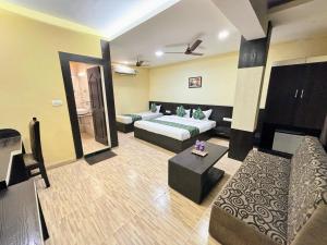 a living room with a bed and a couch at Hotel Wardhman in Jabalpur
