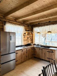 a kitchen with a stainless steel refrigerator and wooden cabinets at Birtvisi Dream House in Abrameti