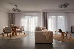 ein Wohnzimmer mit Sofa, Tisch und Stühlen in der Unterkunft The Oak Hotel in Keramotí