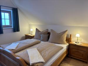 a bedroom with a large bed with pillows and two lamps at Huber's Ferienhaus 28 in Leutschach