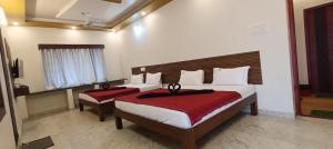a bedroom with two beds with red and white sheets at Mount Coco Resort Yercaud in Yercaud +42 photos