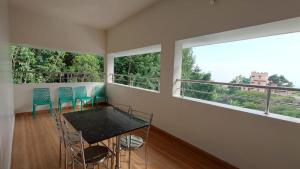 a balcony with a table and chairs and windows at Mount Coco Resort Yercaud in Yercaud