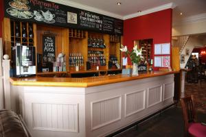 a bar in a restaurant with a red wall at The White House Inn - Whitby in Whitby