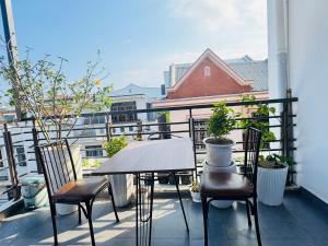 a table and chairs on a balcony with a view at Tue Anh Homestay in Cồn Giả Viên