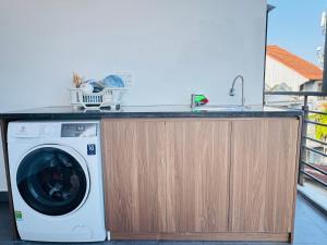 a washing machine under a counter with a sink at Tue Anh Homestay in Cồn Giả Viên