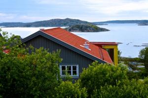 una casa con tetto rosso e un corpo d'acqua di Lådfabriken a Edshultshall