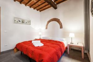 a bedroom with a large red bed with a red blanket at Moka Rooms and Flats in Pisa