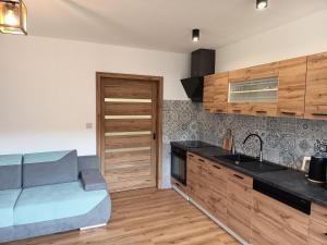 a kitchen with wooden cabinets and a sink at Apartmán U nás in Malá Morávka