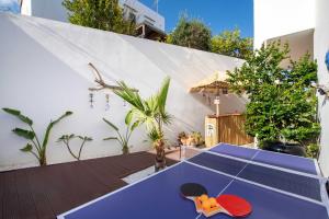 a ping pong table in the middle of a backyard at Outstanding Apartment in an Unique Aegean Inspired Settlement in Agia Triada