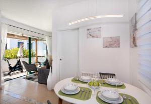 a white dining room with a table and chairs at Outstanding Apartment in an Unique Aegean Inspired Settlement in Agia Triada