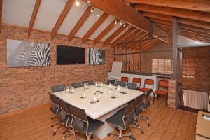 a conference room with a long table and chairs at Africa House Guesthouse in Centurion