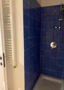 a blue tiled bathroom with a shower with a sink at Luce su Civita in Lubriano