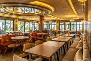 a restaurant with wooden tables and chairs and windows at Wellwood Otel in Sapanca