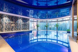 an indoor pool with palm trees in a building at Apartment Pržno See View in Pržno