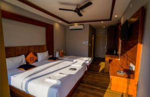 a bedroom with two beds and a ceiling fan at Ganga villa in Jāmb