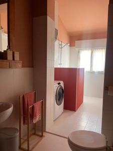 a bathroom with a washer and a washing machine at Urban Po Mansarda in Santa Maria Maddalena