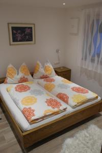 un letto con cuscini colorati sopra di Appartement Fischnaller a Mühlbach