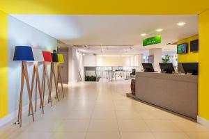 an office lobby with colorful walls and a reception desk at ibis Styles Ribeirao Preto Jardim Botanico in Ribeirão Preto