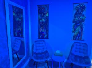 a blue room with two chairs and a mirror at AFI Discret Jacuzzi in Bucharest