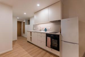 a kitchen with white cabinets and a refrigerator at Komandandi Smart Stay City Center Apartments in Kuressaare +18 photos