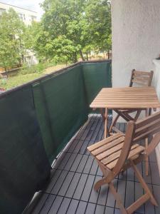a wooden table and chair sitting on a patio at Eliza Apartman Veszprém in Veszprém