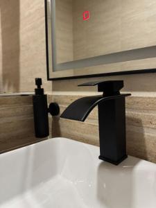 a bathroom sink with a black faucet next to a mirror at Annavilla7 Lilongwe hotel in Lilongwe +58 photos